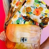 Elect leather shoulder bag with twist clasp, adjustable strap, and multiple interior and exterior pockets.