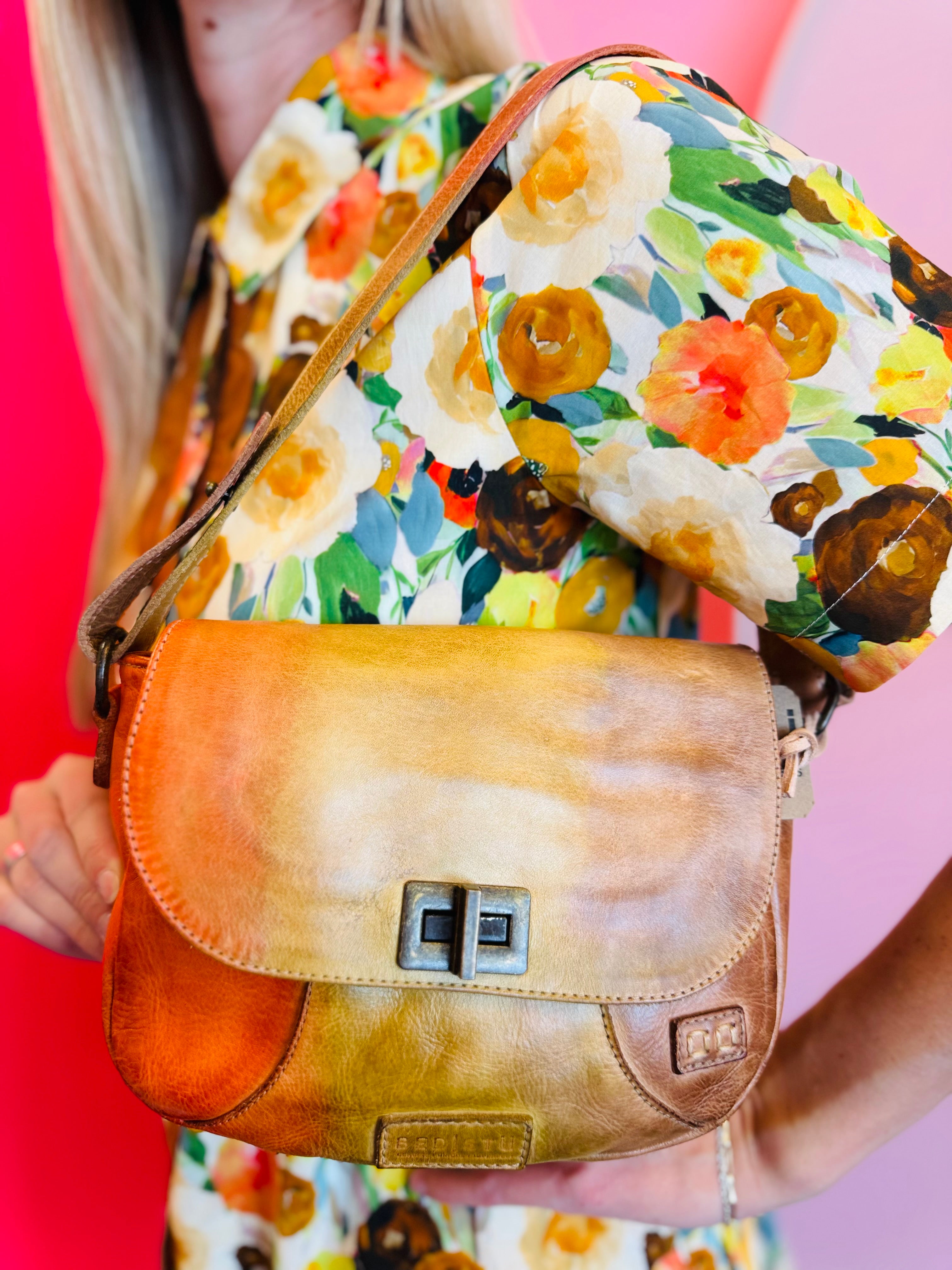 Elect leather shoulder bag with twist clasp, adjustable strap, and multiple interior and exterior pockets.