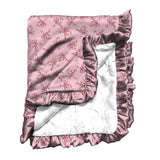 pink satin blanket featuring small red candy canes and bows & trimmed with ruffle