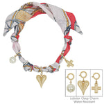 Red and white knotted scarf necklace with puffy heart, open cross, and bow charm.