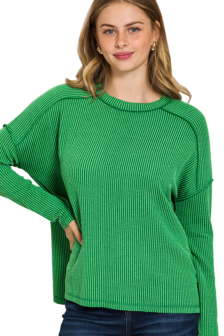A dark green ribbed boat neck top. The top has long sleeves, a relaxed fit, and raw edge details on the seams.