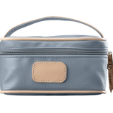 A slate colored Jon Hart mini makeup case with natural leather trim and a leather patch for personalization.