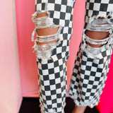 Knee view black and white cropped checkered jeans with knee distressing.