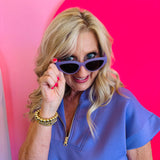 Model playfully posing with Dime Last Call Lavender Fog Polarized Sunglasses pulled slightly down, showcasing the sleek cat-eye shape and soft lavender frame.