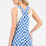 Blue checkered sleeveless romper overalls with adjustable straps, cuffed shorts, and multiple pockets, laid flat to show details.