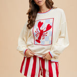 Cream long-sleeve sweater with a large red checkerboard lobster graphic and red striped trim.