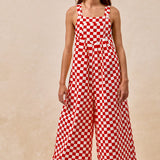 A pair of overalls with a red and white checkerboard plaid print. The overalls have adjustable straps, front pleats, and a wide-leg silhouette.