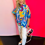 Full-body view of the Blue Printed Blouse styled with white pants and a white handbag, highlighting the blouse’s loose fit and everyday elegance.