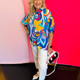 Full-body view of the Blue Printed Blouse styled with white pants and a white handbag, highlighting the blouse’s loose fit and everyday elegance.