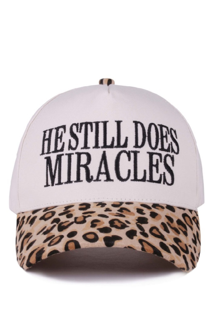 Leopard print cap with “He Still Does Miracles” embroidered on the front.
