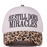 Leopard print cap with “He Still Does Miracles” embroidered on the front.