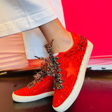 Side profile of red vegan leather sneaker featuring a bold rhinestone star embellishment and slight platform heel with leopard laces.