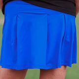A close-up of a blue tennis skort with pleated back and side pockets