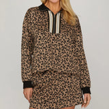 A long-sleeve knit top with a classic leopard print. The top features a half-zip collared neckline, cuffed sleeves, and contrasting black ribbed trim.