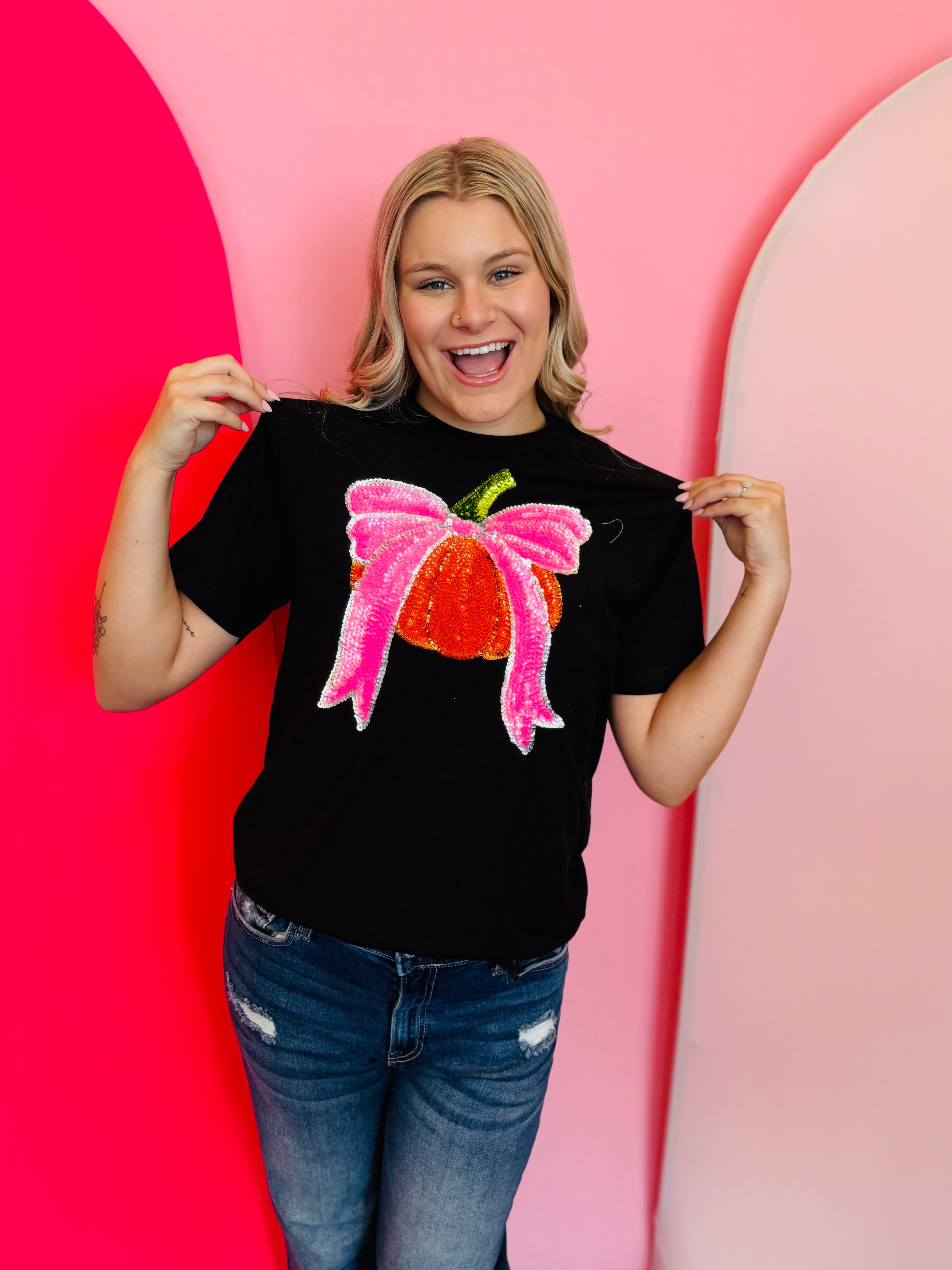 Black tee with sequin orange pumpkin graphic and bright pink sequin bow.