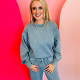Blue grey acid wash fleece sweatshirt with exposed seams, side slits, and a bottom band.