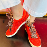 PIcture of red vegan leather sneaker featuring a bold rhinestone star embellishment and slight platform heel with leopard laces.