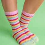 A pair of fuzzy, plush crew socks with a vibrant horizontal stripe pattern in a variety of rainbow-inspired colors.