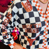 Close up of Queen of Sparkles UT orange and black checkered cardigan with sequin and beading and rhinestone buttons.