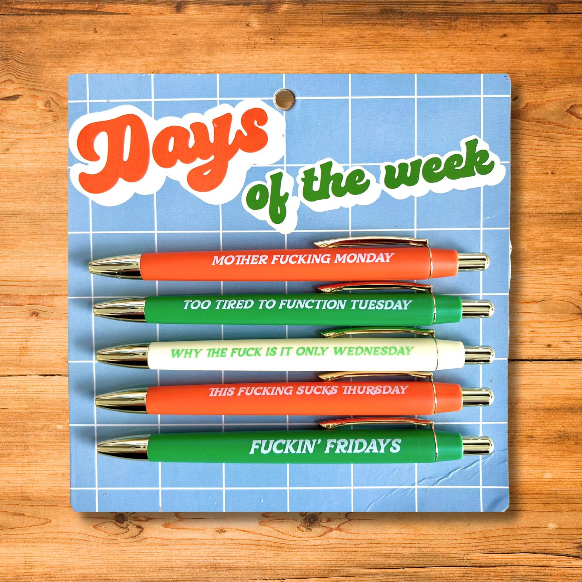 Set of pens with humorous phrases on a blue grid background