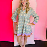 Sage floral dress with lavender and rust neckline, hemline, and cuffs