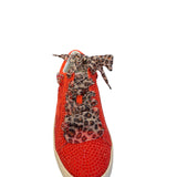 Front view of red embellished sneakers with leopard lace-up detail, close round toe, and rhinestone star accents on the sides.