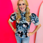 Navy ruffled mock neck floral top with short sleeves, stripe contrast trim, and pastel floral print.