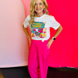 Full outfit view featuring the Vaya Con Dios Tee styled with bright pink pants for a cheerful and vibrant look.