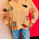 Close up of Queen Of Sparkles orange and white striped icon Oklahoma State University game day blouse.