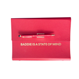 Red clutch organizer with a pen and 'Baddie is a State of Mind' text.
