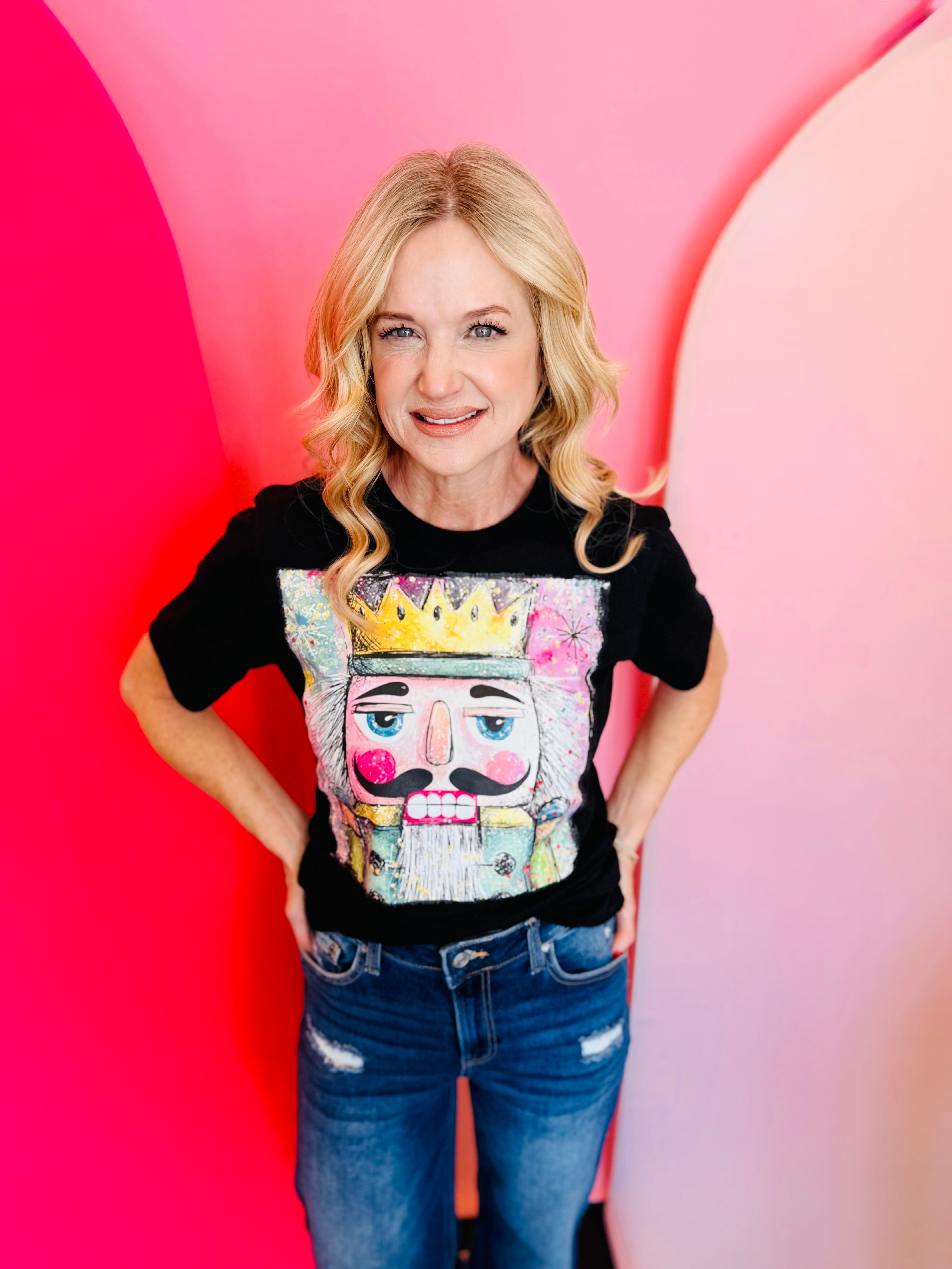 Black tee with colorful nutcracker king graphic in a square design.
