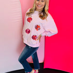 Pastel pink sweatshirt with sequin pumpkins and embroidered bow accents