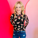 Sheer mesh top with neon holiday tree print, pink stars, mock neck, and lettuce hems.