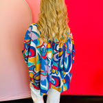 Back view of the blouse displaying the pinched detail at the upper back and the relaxed silhouette of the lightweight fabric.