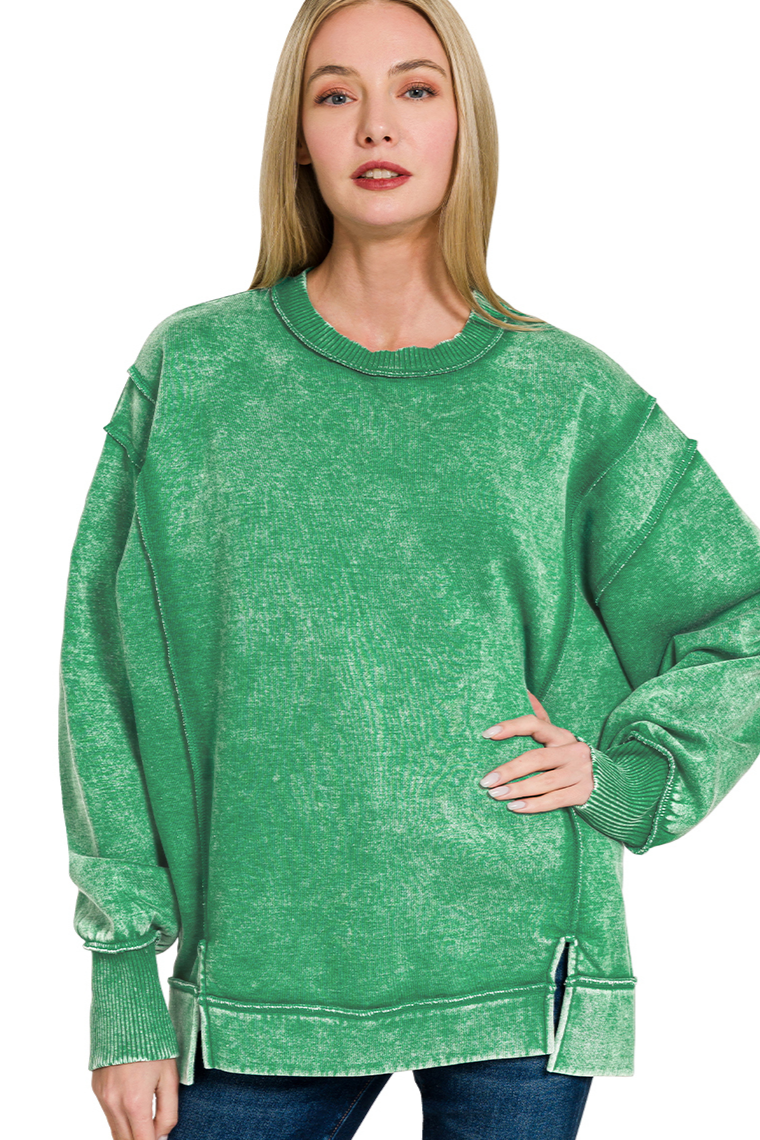 A relaxed-fit, forest green acid wash fleece sweatshirt. The sweatshirt has visible exposed seams and a side slit at the bottom.