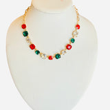 Gold-tone necklace with red, green, and clear faceted crystals for festive sparkle and elegance.