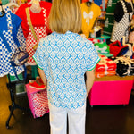 back view of blue and white geometric floral half zip top
