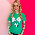 Green tee with large white bow graphic and black “Game Day” lettering on the front.