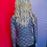 Back view of the Keigan Mesh Top showcasing the playful chocolate checkered print, sheer lightweight mesh fabric, and stylish lettuce-edge hem, offering a bold and breathable statement piece perfect for layering.