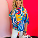 Full-body view of the Blue Printed Blouse styled with white pants and a white handbag, highlighting the blouse’s loose fit and everyday elegance.
