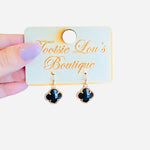 Glossy black clover dangle earrings with gold trim, lightweight and shiny for everyday or elegant wear