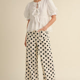 White wide-leg pants with black polka dots, hidden zipper closure, back stretch waistband, and side pockets.
