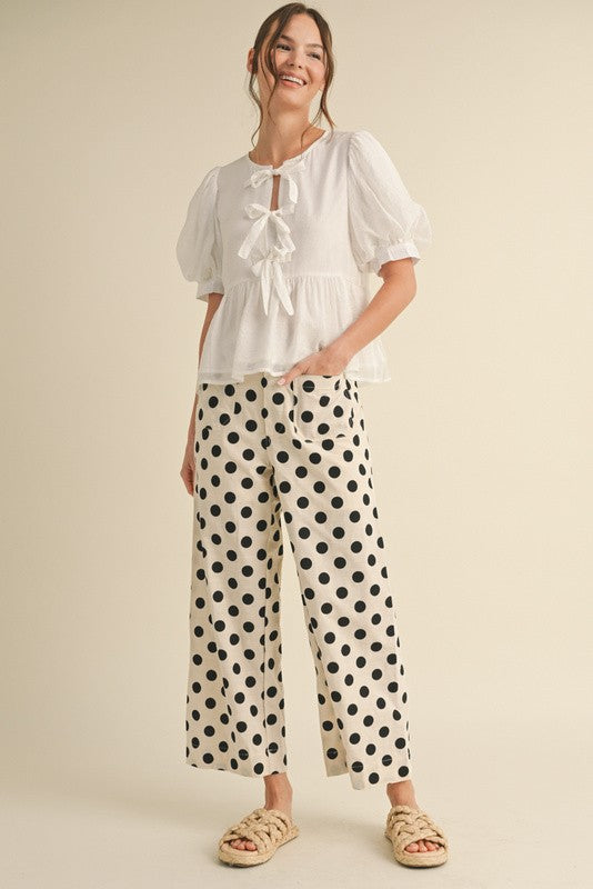 White wide-leg pants with black polka dots, hidden zipper closure, back stretch waistband, and side pockets.
