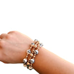 Water-resistant bracelet stack with glossy gold and black and white Chinoiserie beads.