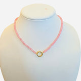 Blush Glow Necklace with faceted pink beads, gold central bead with charm clip, and magnetic clasp.