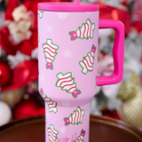Pink Christmas tumbler with bow-topped holiday treats, hot pink handle, and reusable straw.