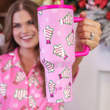Pink Christmas tumbler with bow-topped holiday treats, hot pink handle, and reusable straw.