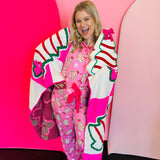 Pink Christmas pajama set with holiday treat print, ruffle trim, and drawstring pants.