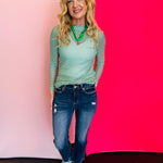 a long sleeve, crewneck mesh top with bold, horizontal stripes in vibrant green and crisp white.