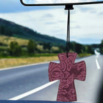 Cross-shaped hair-on-hide and leather car freshener charm, stitched design.